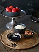 Red eggs, black sesame seeds, flour and nuts in bowls