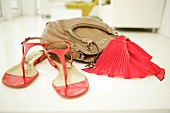 Close-up of handbag, red scarf and flat sandals