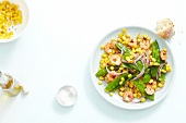Corn and mange tout salad with shrimp on plate