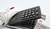 Calculator, multiple plugs and bulbs on white background