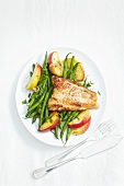 Fish fillets with green beans and apple on plate