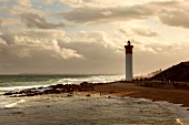 View of Umhlanga beach with rocks and lighthouse at dusk, South Africa