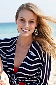 Portrait of beautiful blonde woman with windswept hair wearing stripe shirt, smiling