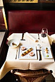 Table laid with veal loin with bacon colonnata with red wine glass