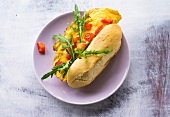 Omelette burger with baguette bread, tomato and arugula on plate
