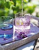 Close-up of water being poured in two glasses on tray