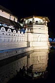 View of Sri Dalada Maligawa temple and reflection in water at night, Kandy, Sri Lanka