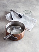 Casserole, sterilized glasses on towel with tongs