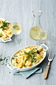 Potato and asparagus gratin on serving dish served with wine