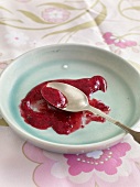 Berry jam with spoon on plate
