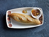 Baguette and jam in bowl on tray