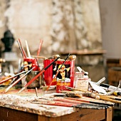Paint brushes with paints on table in studio of John Grutzke, Berlin, Germany