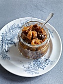 Dried fruit jam in jar with spoon on plate