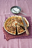 Ground pork and vegetable quiche on baking tray with knife