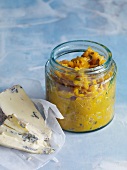 Pumpkin sage jam in jar and soft cheese pieces on paper