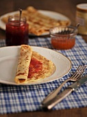 Pancakes with jam and marmalade on plate