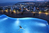 View of person swimming in pool of Hotel The Marmara Pool and cityscape in Bodrum, Turkey