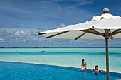 Parasol at swimming pool in front of sea, Dhigufinolhu island, Maldives