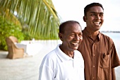 Two men smiling on beach of Veliganduhuraa, Maldives