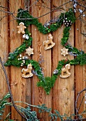 Star made ??of fir branches with gingerbread on wooden wall