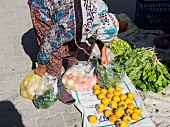 Woman picking up vegetables in weekly market in Yazikent, Aegean, Turkey