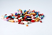 Close-up of various capsules, tablets and dragees on white background