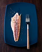 Smoked char fillet with fork in serving dish