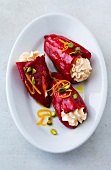 Red peppers stuffed with cream cheese and garnished with pistachios on plate