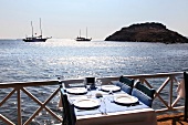 View of sea and table laid at Mimoza Restaurant, Gumusluk, Aegean Region, Turkey