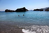 People relaxing in Aegean Sea and view of rocks in sea, Turkey