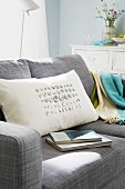 Cremeweisses Kissen mit aufgenähten Perlmuttknöpfen auf Sofa