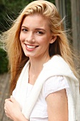 Portrait of beautiful blonde woman with long hair wearing purple top, smiling