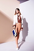Pretty woman wearing white jacket over brown silk blouse and skin colour leather pants
