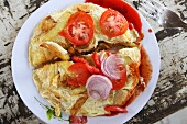 Omelette with tomato and onions on plate in Zanzibar, Tanzania, East Africa