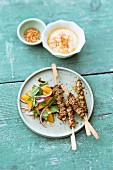 Oriental lamb skewers served with and onion and orange salad with mint and chickpea puree