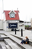 Woman sitting on the terrace of Herbern Marina restaurant in Oslo, Norway