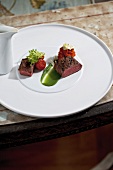 Venison with green turnip, tomato and mashed roe on plate
