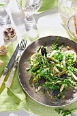 Asparagus salad with arugula, lemon, white asparagus, pine nuts and blackberries on plate