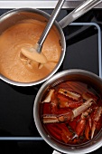 Preparation of lobster and egg dip in saucepans on a hob