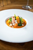 Close-up of carrots with foie grass and mint macadamia nuts on serving dish