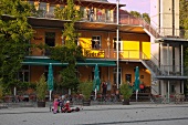 People sitting outside cafe of restaurant Alfred Doblin-Platz in Vauban, Freiburg, Germany