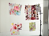 Variety of table cloth with floral print hanging on cloth line