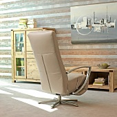 Beige armchair against wooden cabinet and striped wall