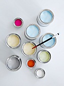 Light blue, white, pink and orange paint in colour pots on white background