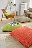 Orange, green and beige pillows on floor with wood chair on side