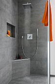 Open rain shower with orange towel in luxury bathroom