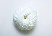 Close-up of white ball of wool on white background