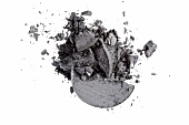  Close up of gray loose and crumbled eye shadow on white background 