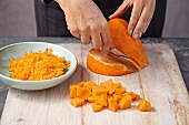 Grating and cutting squash on wooden board