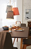 Pendant lamps with knitted shades in brioche stitch hanging above a dining table